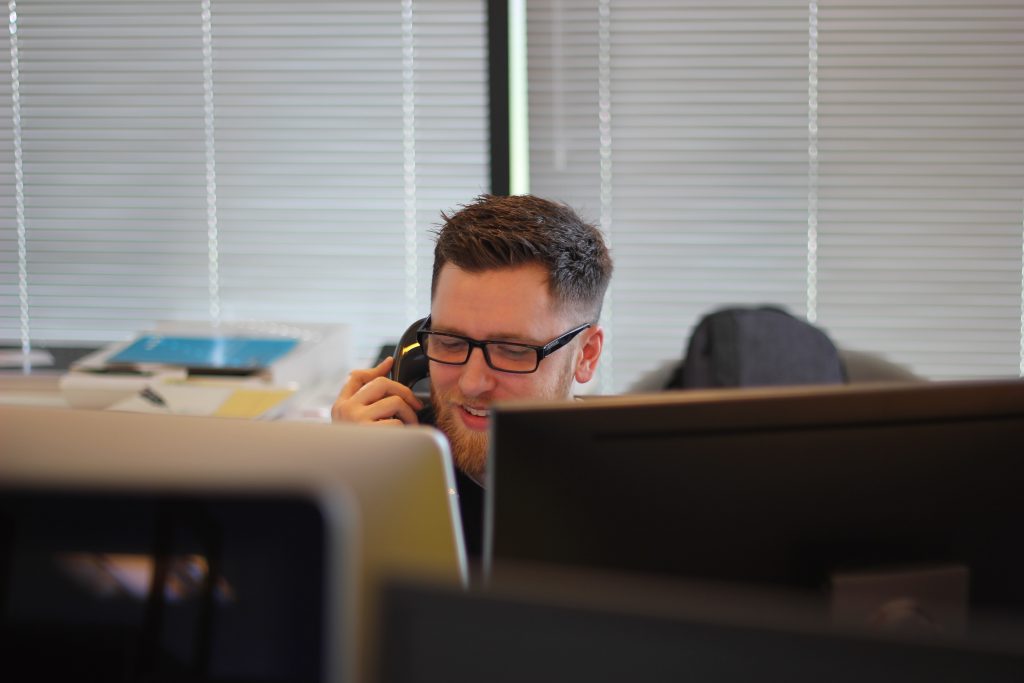 man on phone behind computer
