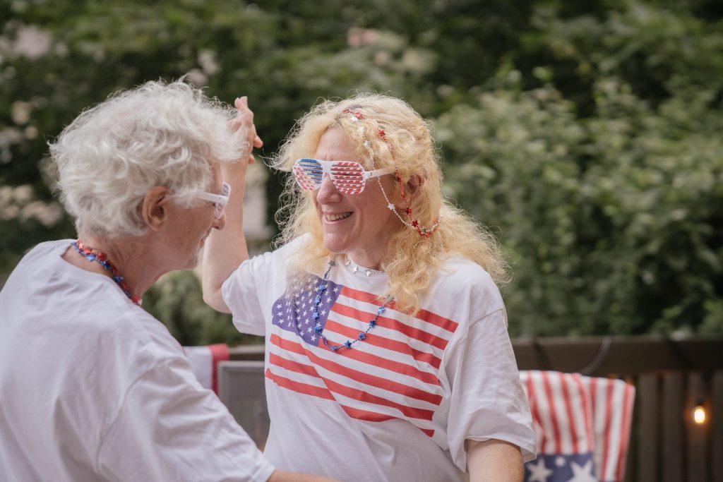 Couple wearing American flag shirts and glasses dancing